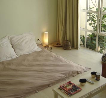 Garden Suite at Rosedene Lodge with a low bed, coffee table and tall windows onto the garden